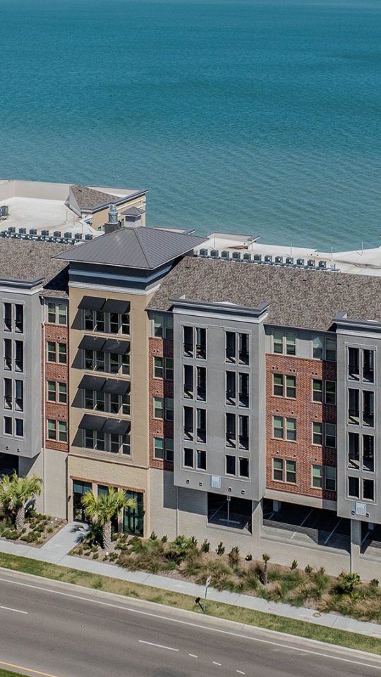 an aerial view of a large apartment complex near the ocean at The  Alexa