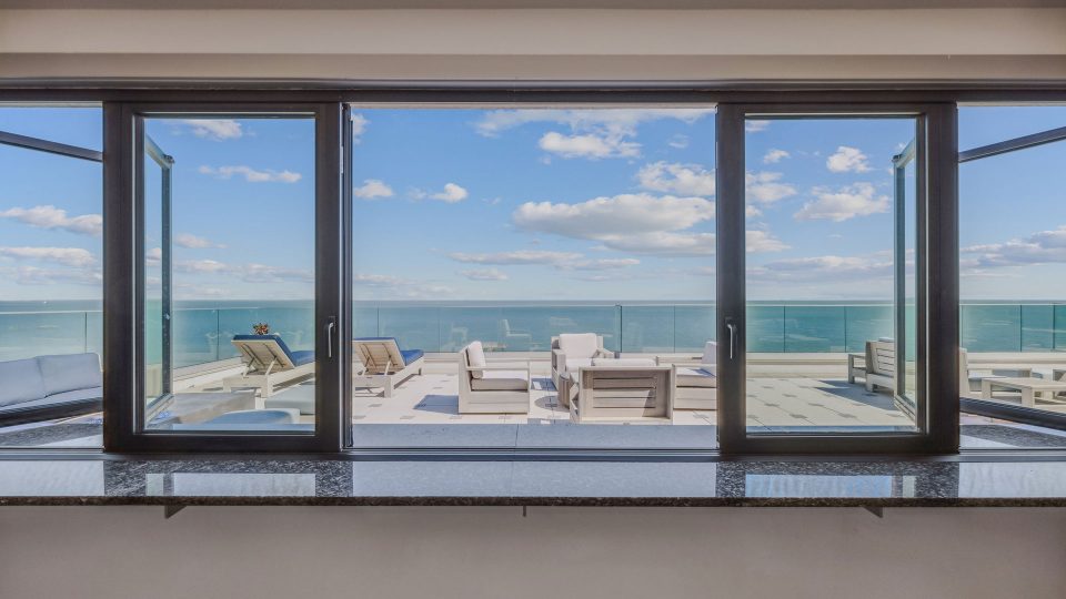 a large window overlooking the ocean and the beach at The  Alexa